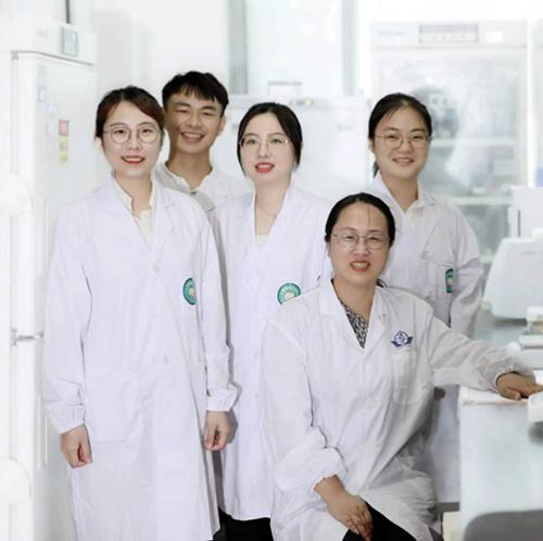 Team of five scientists in white lab coats